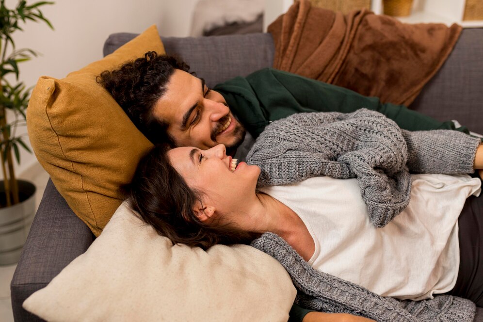 smiley-wife-husband-lying-sofa