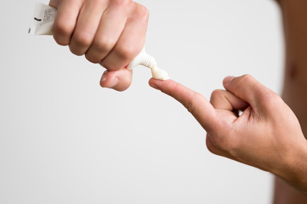 man-squeezing-cream-from-tube-his-finger
